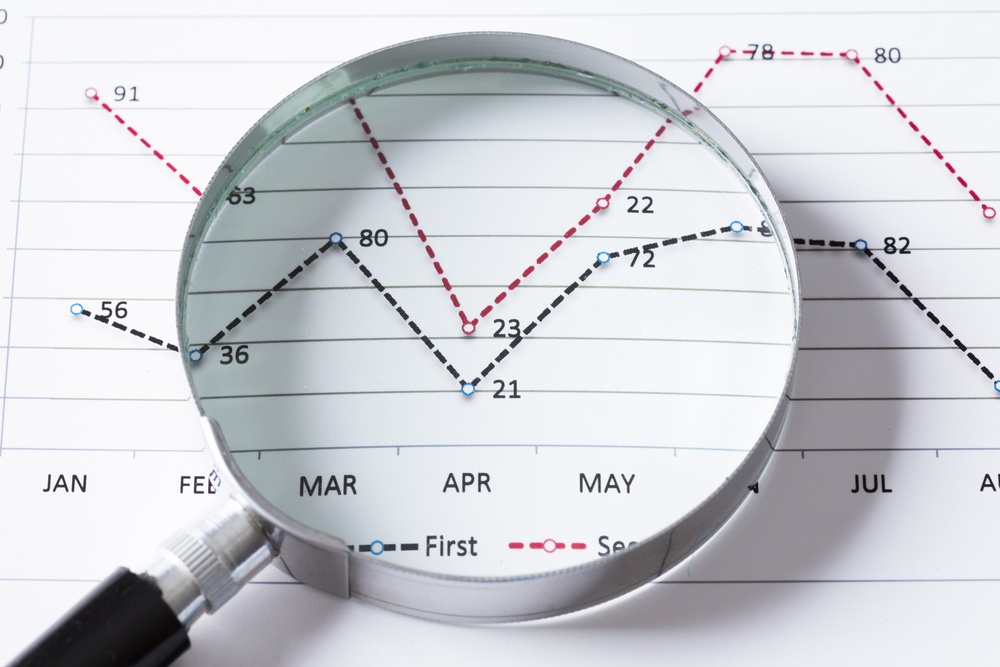 Magnifing glass and documents with analytics data lying on table Magnifing glass and documents with analytics data lying on table