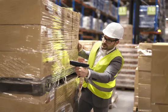 warehouse worker quickly scanning boxed inventory