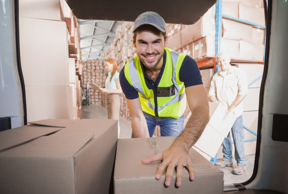 Delivery driver loading his van with boxes outside the warehouse Delivery driver loading his van with boxes outside the warehouse